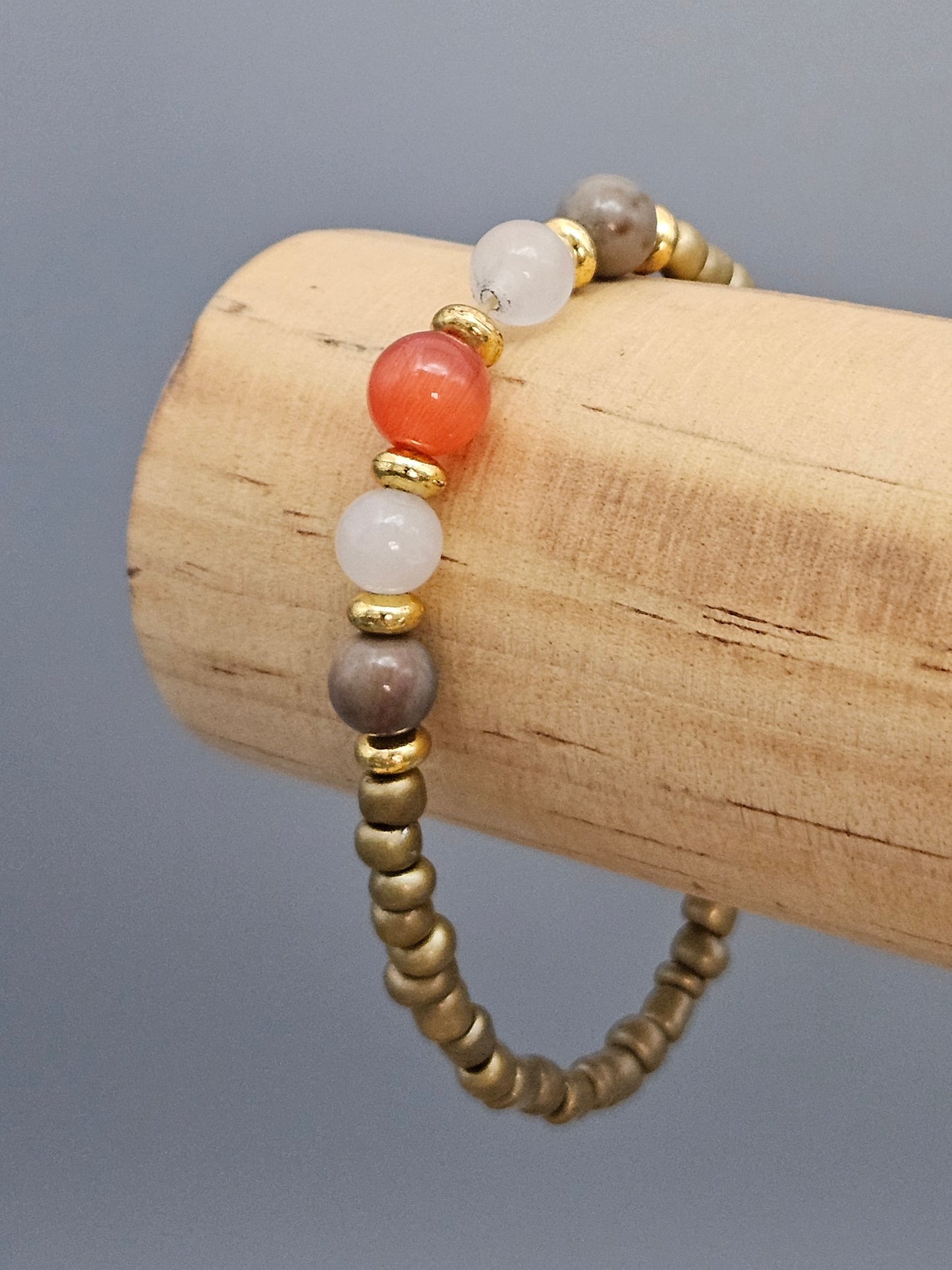 Bracelet Lune & Or — perles dorées et perle œil de chat rouge sur montage élastique