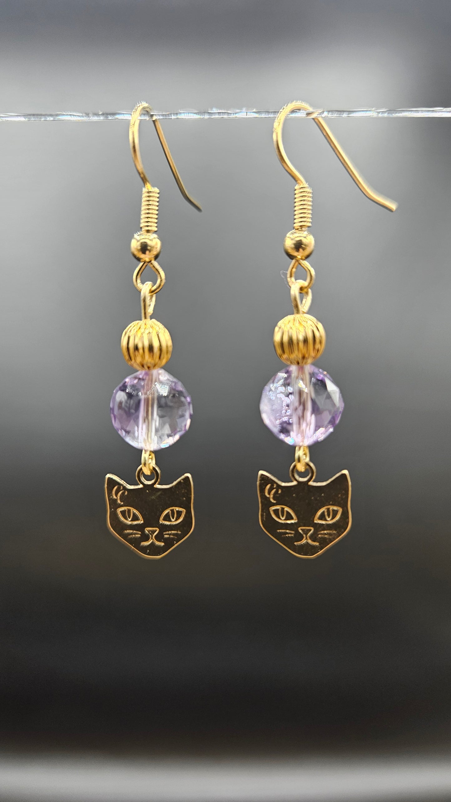 Boucles d'oreilles pendantes dorées avec perle cristal mauve et breloque patte de chat